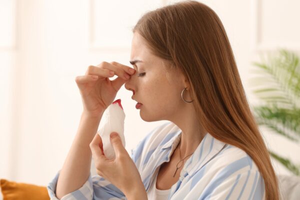jeune femme saignant du nez avec un mouchoir