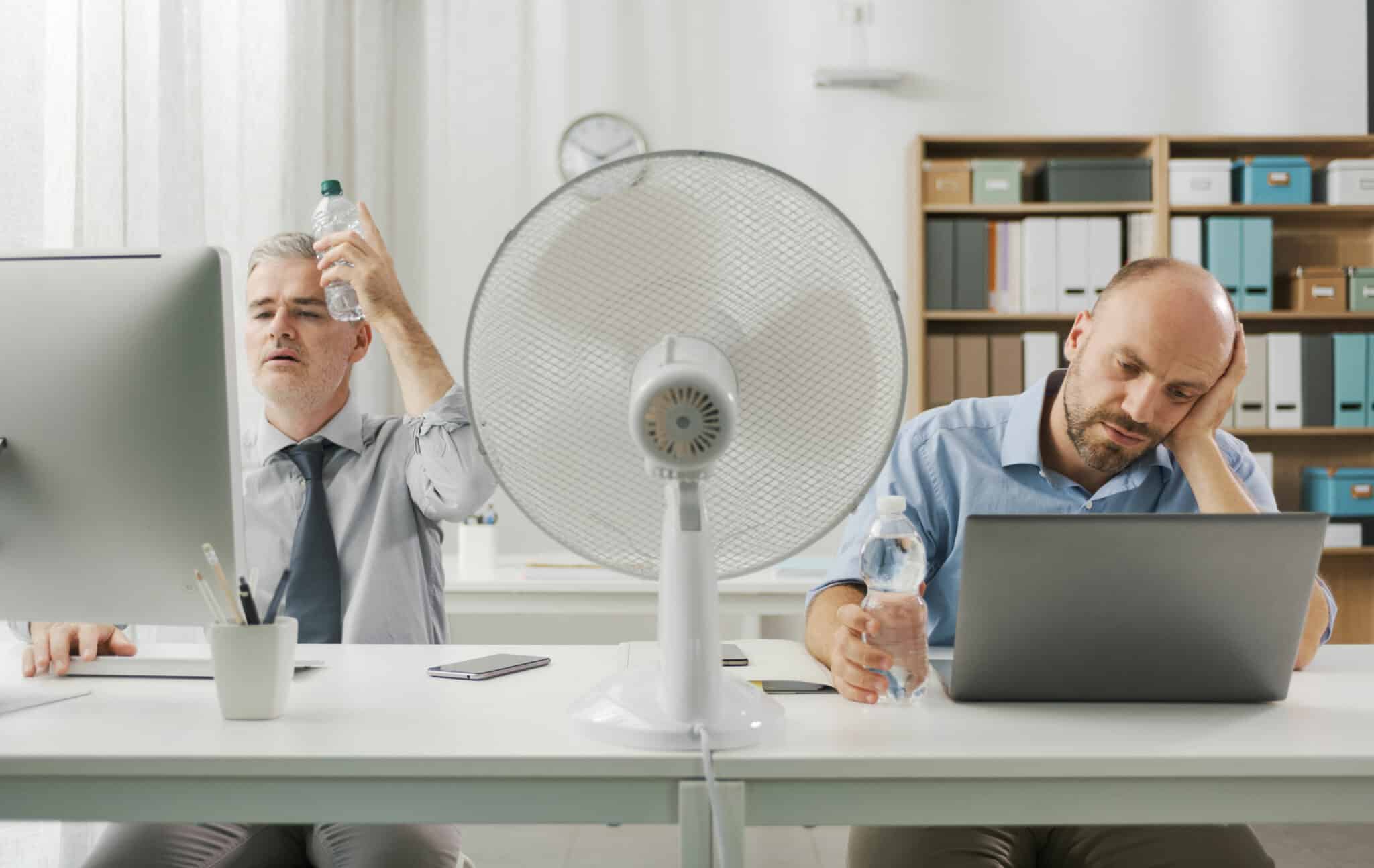Deux employés de bureaux souffrant de la chaleur à cause de la canicule
