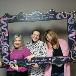 3 femmes en rose tenant un cadre avec des citations octobre rose